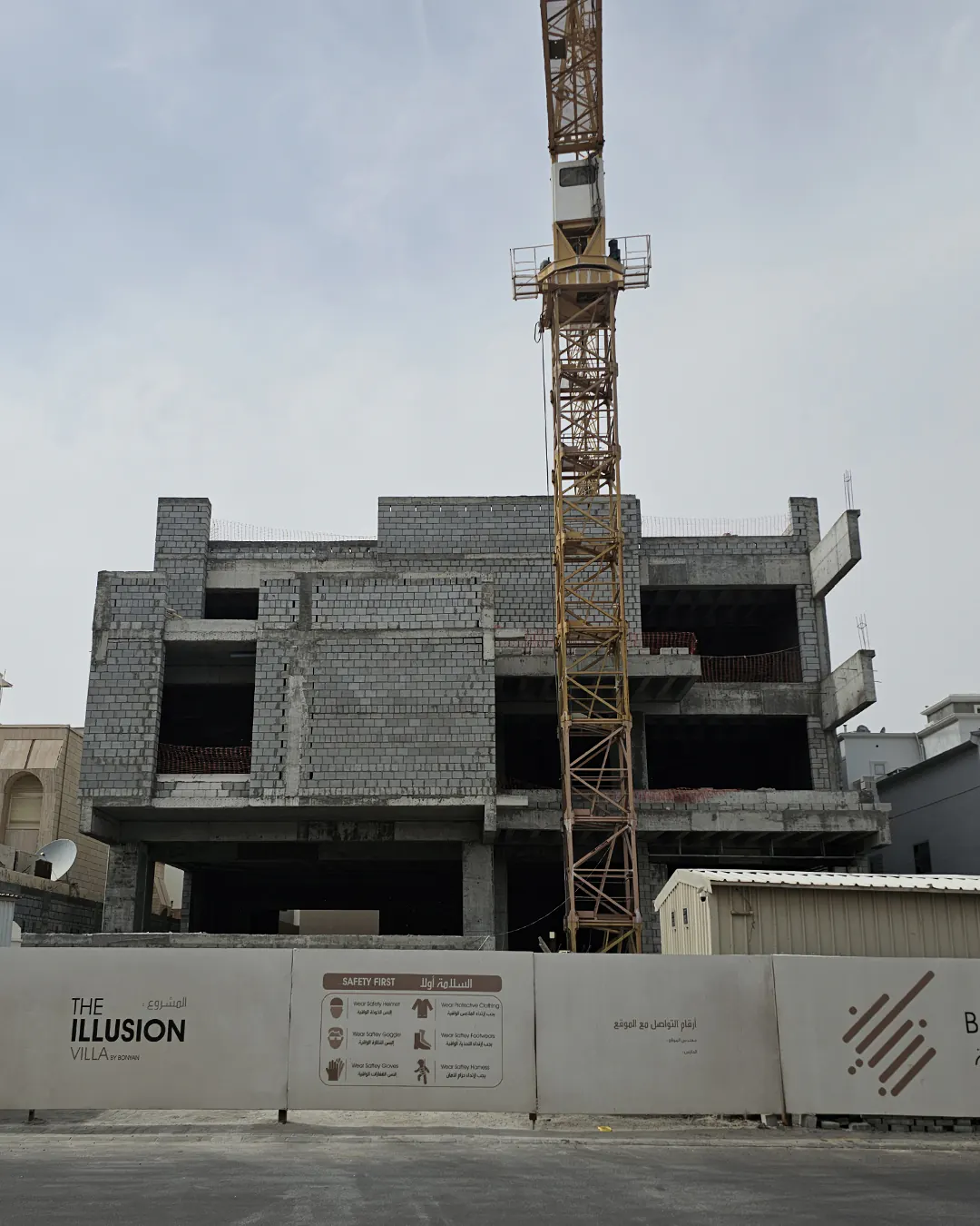 A mid-construction view of Illusion Villa showing reinforced concrete slabs, formwork, and a tower crane operating on site.